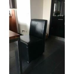 Zwart leren eetkamer stoelen en bank,zes ruime zitplaatsen.