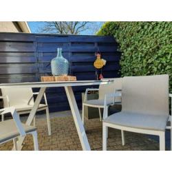 Witte zgan rond tuinset, tafel en stoelen