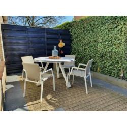 Witte zgan rond tuinset, tafel en stoelen
