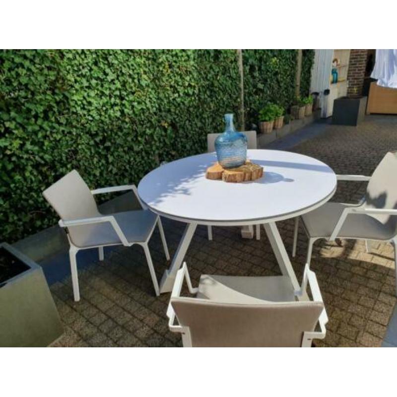 Witte zgan rond tuinset, tafel en stoelen
