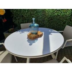 Witte zgan rond tuinset, tafel en stoelen